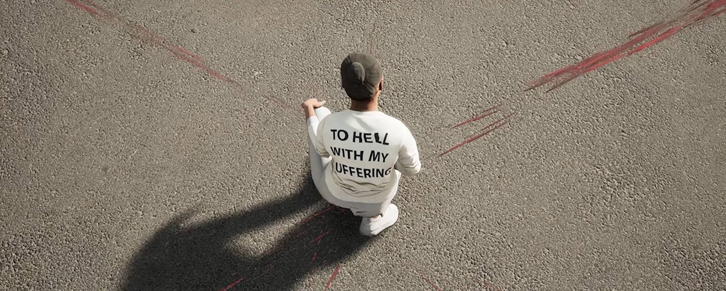 Image of a person from above. They are wearing a white top which has the words 'TO HELL WITH MY SUFFERING' on the back. They stand on tarmac.