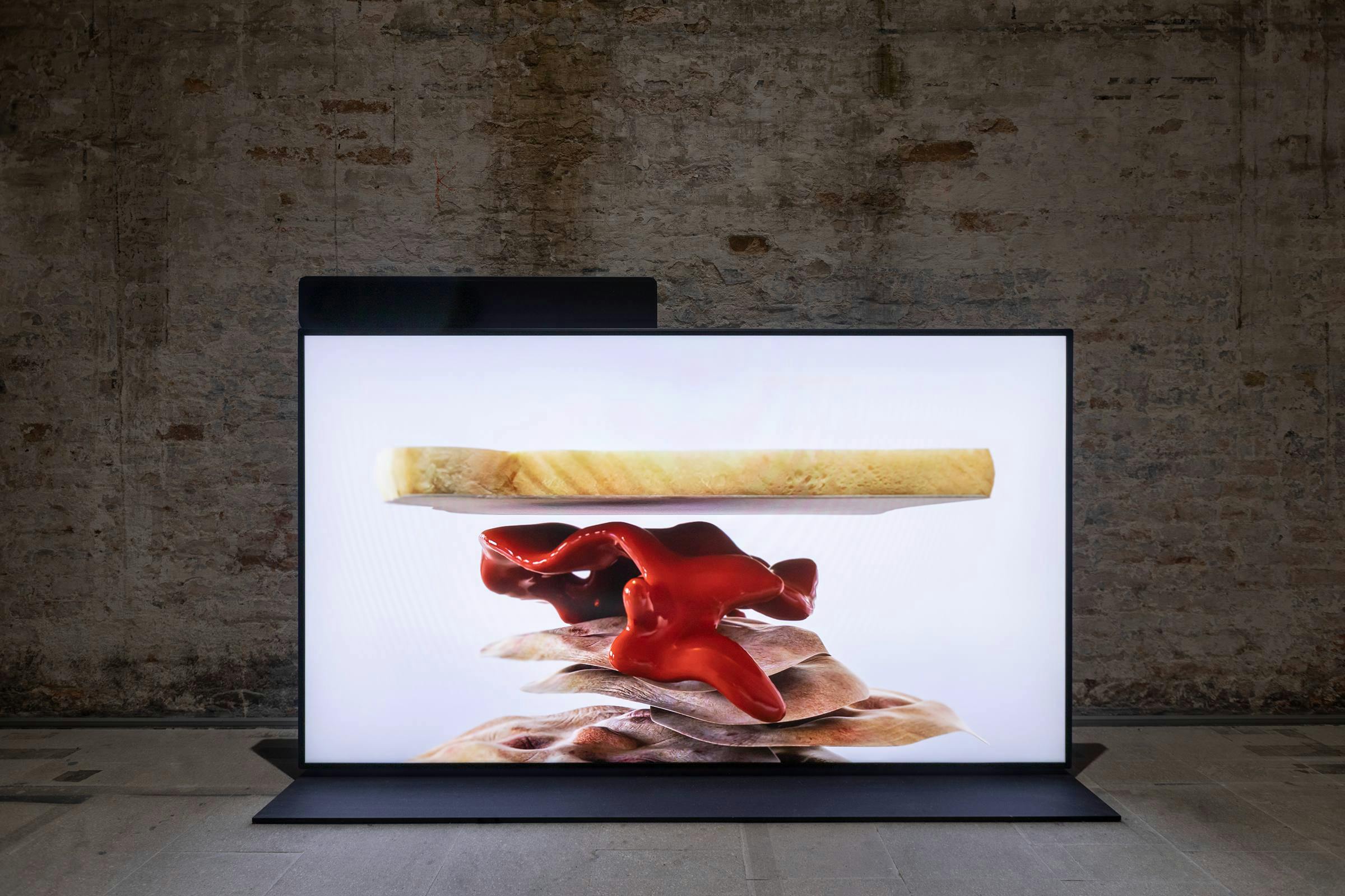 installation view of Untitled by Ed Aktins. The work is playing on a free standing screen installed in an industrial space