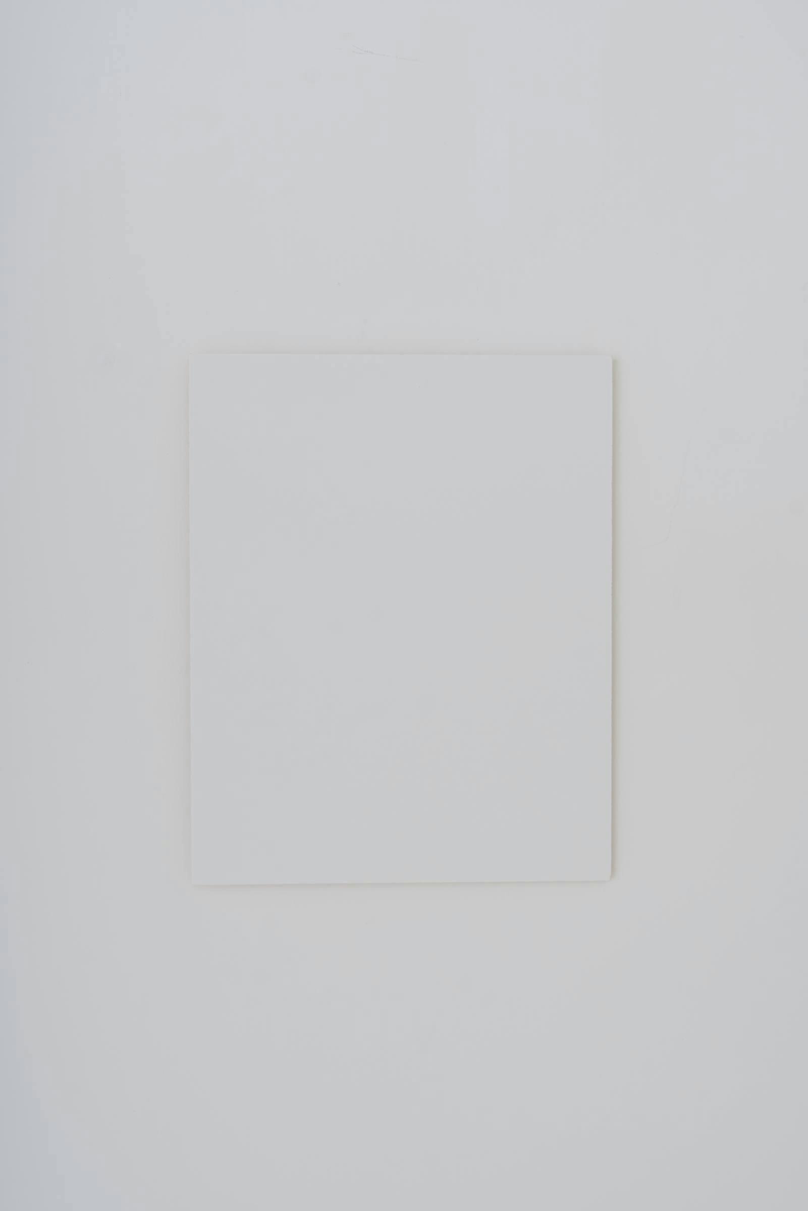 Image of a white canvas hung on a white wall.