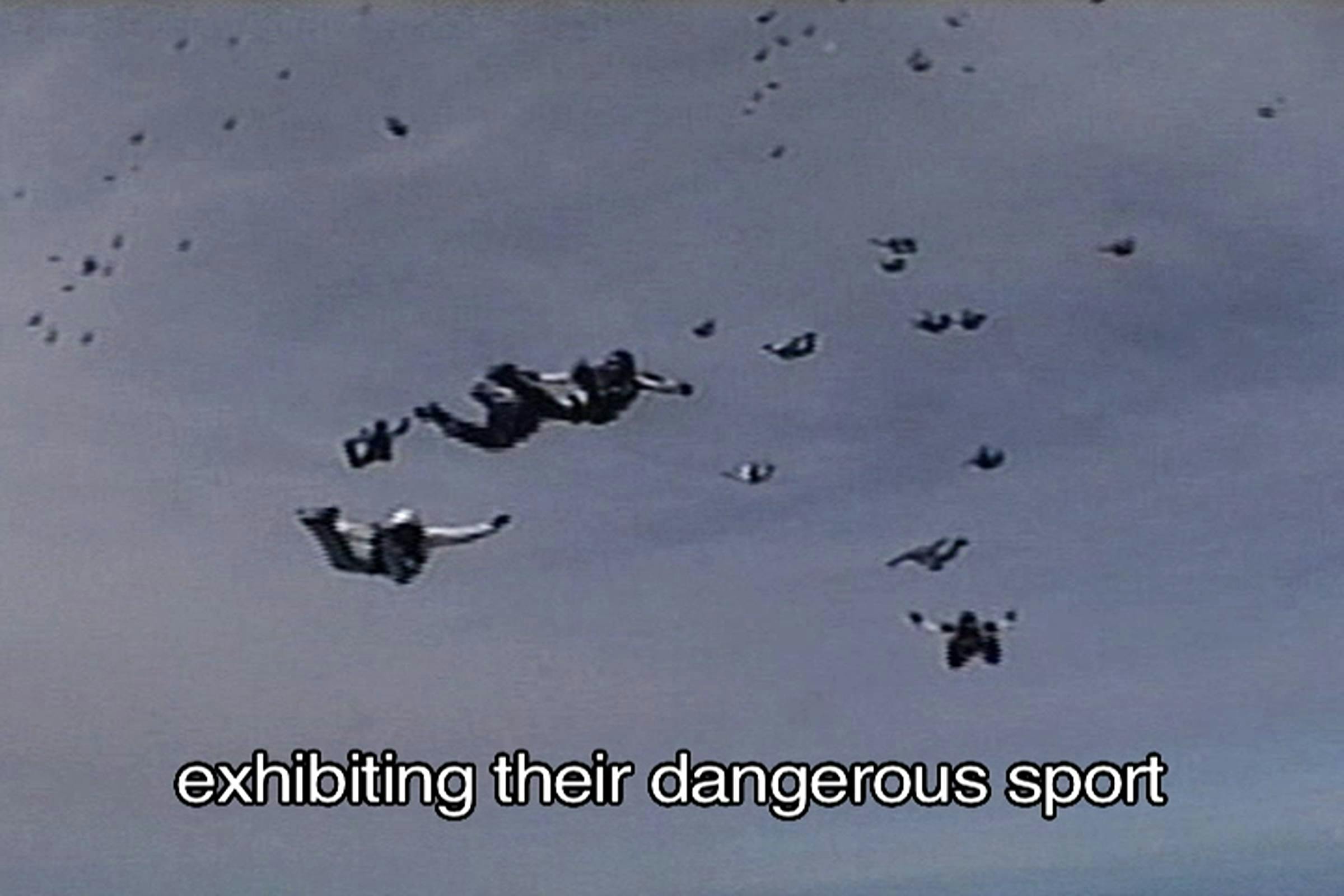 Image of tens of people skydiving with the words 'exhibiting their dangerous spot' like a caption at the bottom of the screen