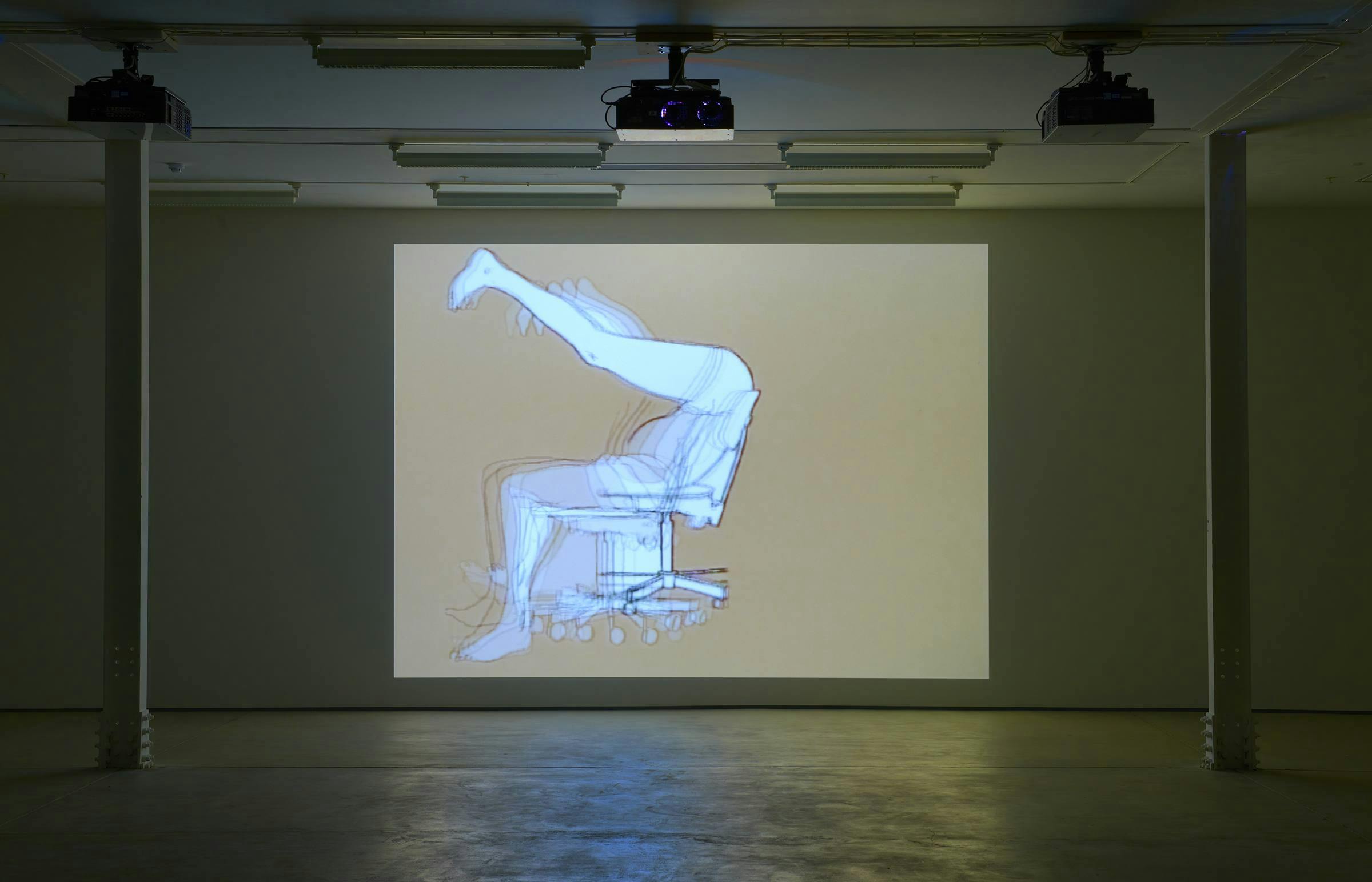Image of a video shown in a gallery space with a projector overhead and a column either side of the projection
