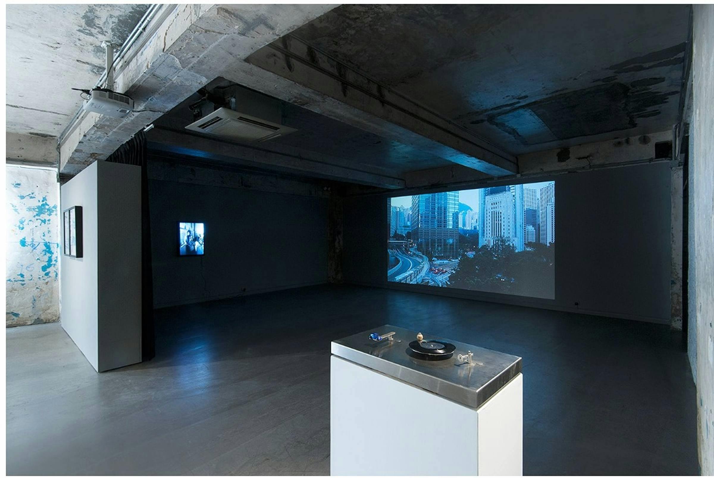 Gallery image of two images being projected onto the walls and a plinth in the foreground.