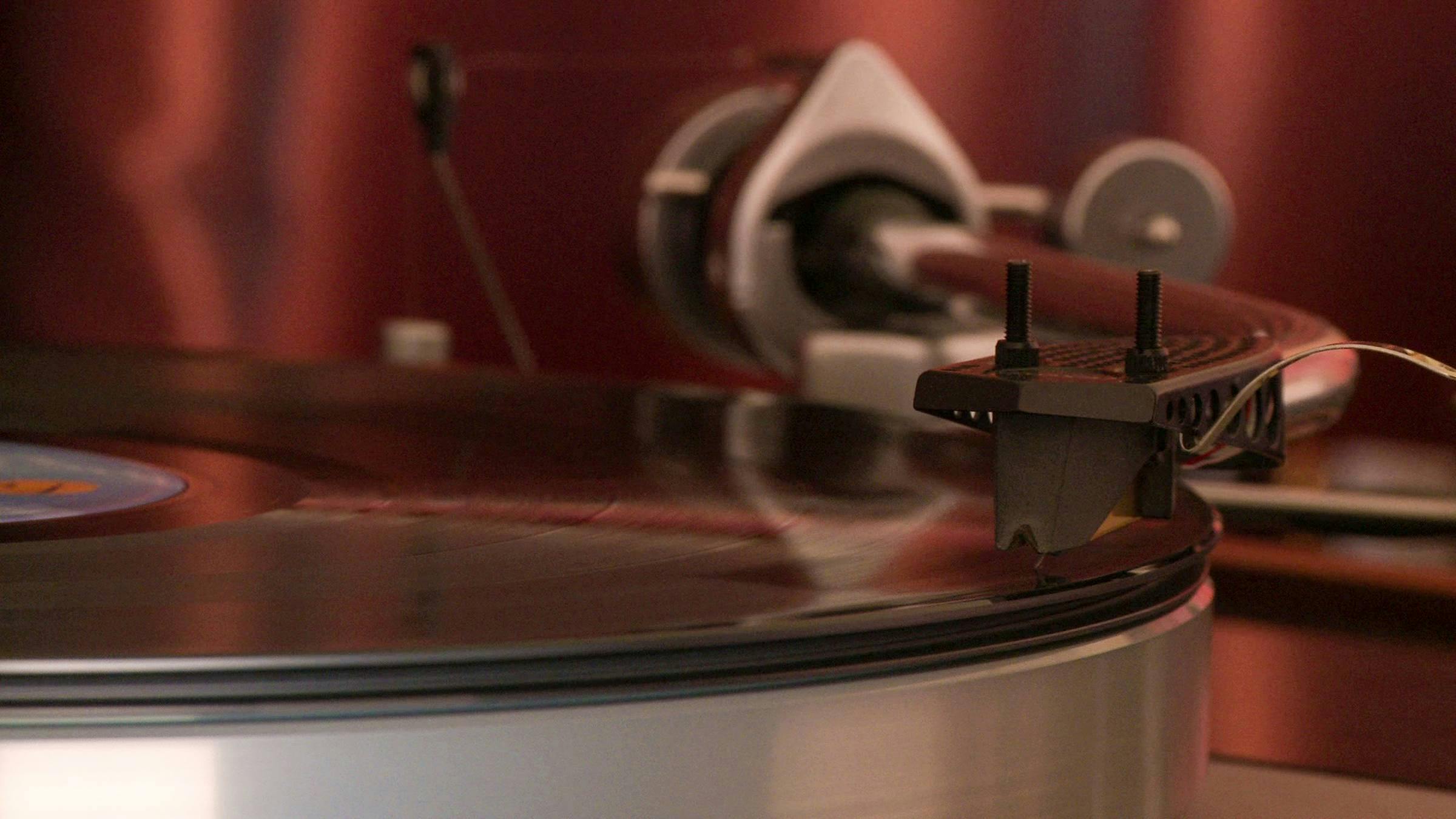 a close up of a record player stylas playing a vinyl record. 