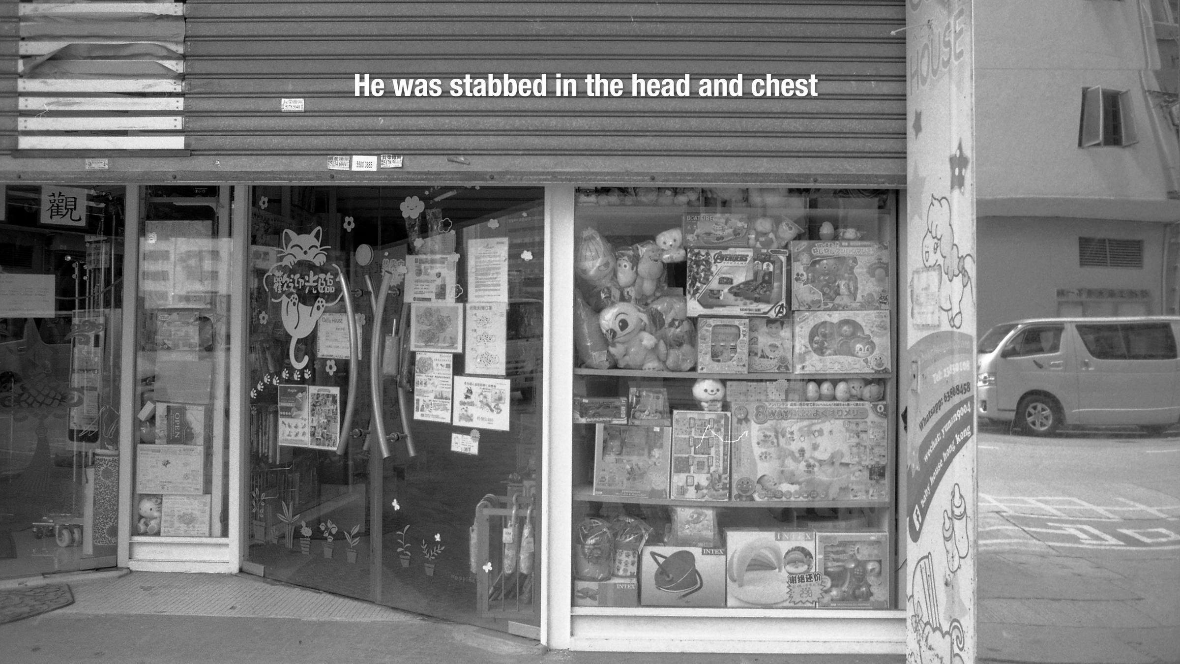 Black and white image of a shop front containing lots of toys. At the top, the words 'He was stabbed in the head and chest' are superimposed.