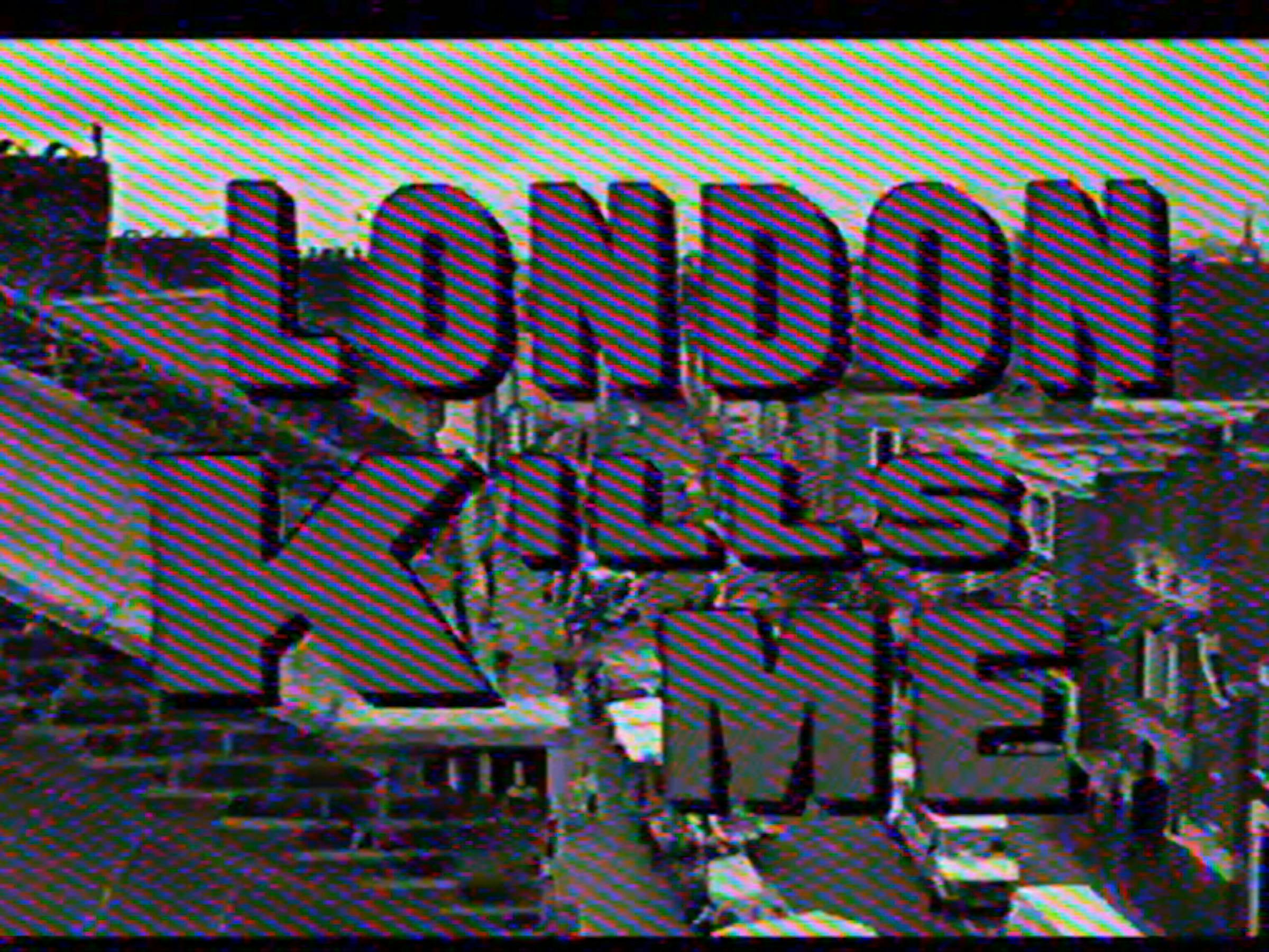 an image of a tv screen with the words 'london kills me' written in purple block capitals floating in front of a road in a city