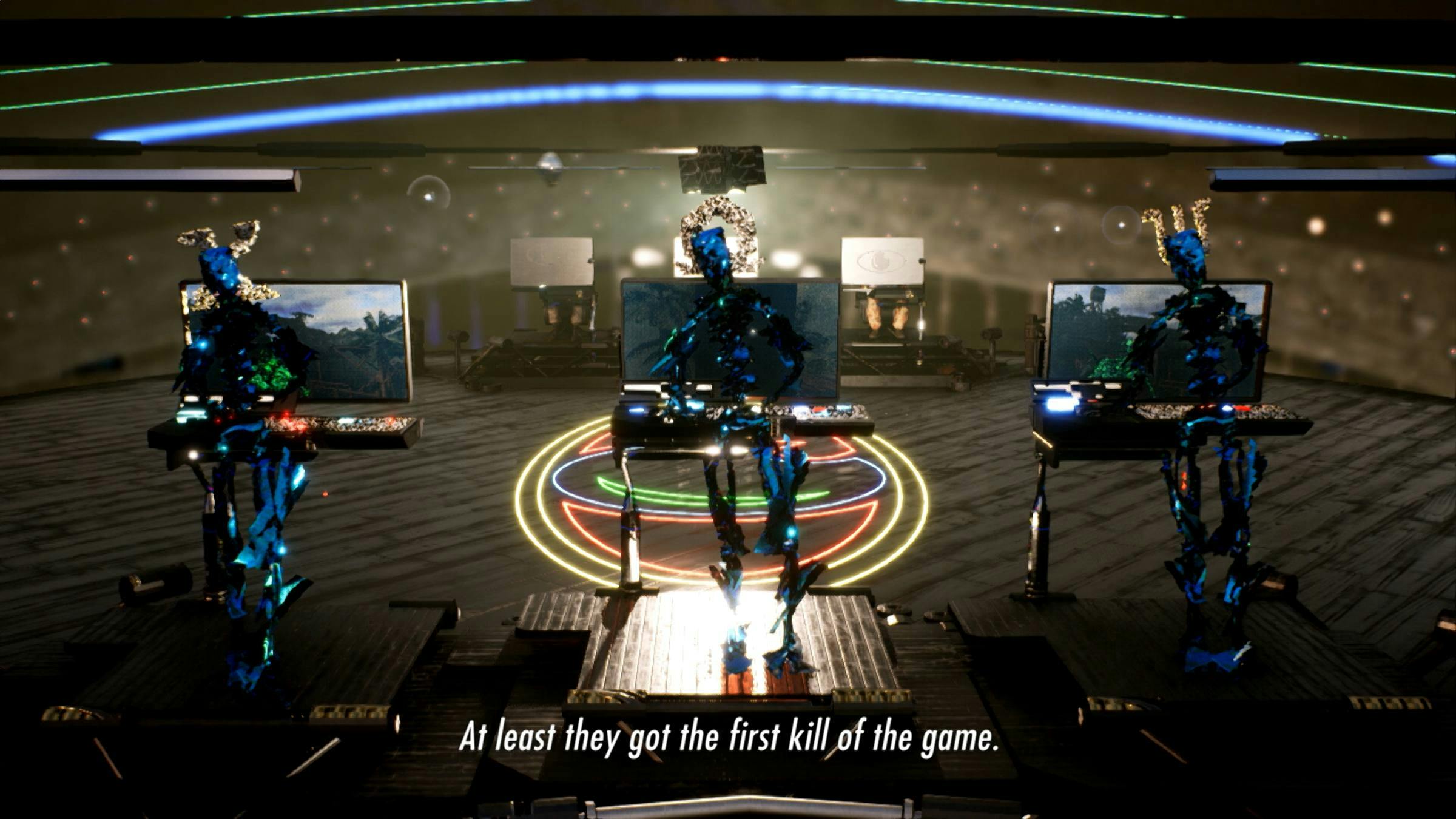 Three robotic figures sit in a futuristic looking space, lit by different colored lights. The words ' At least they got the first kill of the game' are superimposed on top.