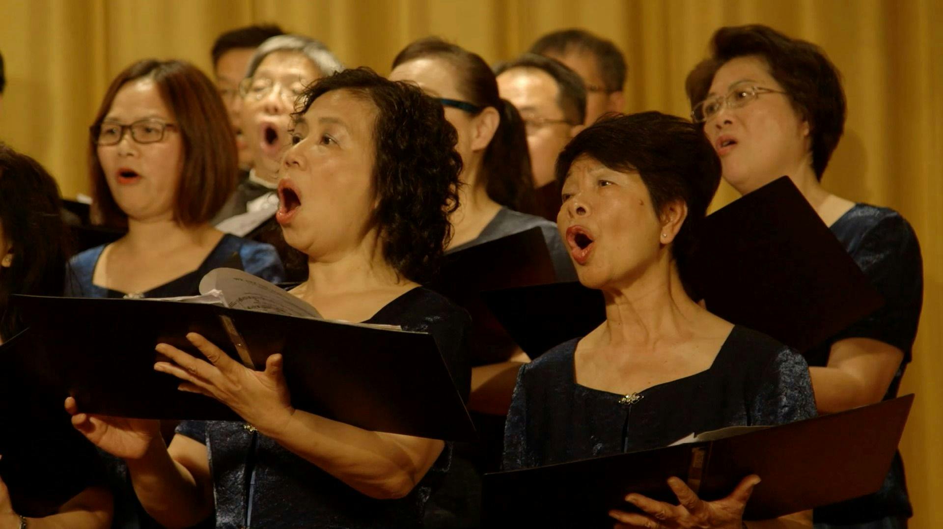 A close up image of people in Beijing, China singing in a choir