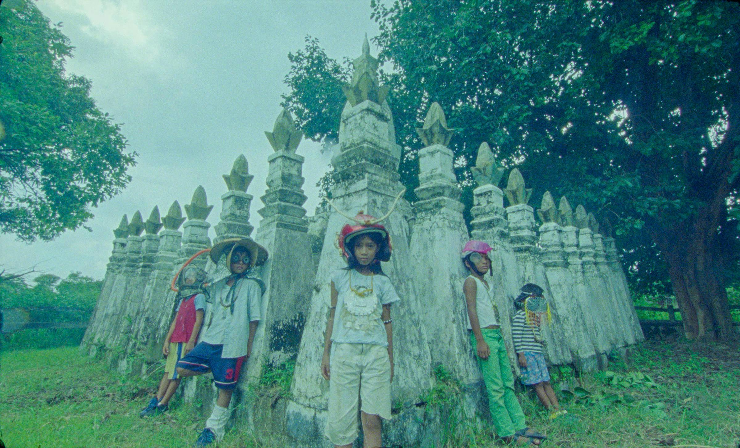 6 children stand in front of a stone monument in Bataan in the Philippines.