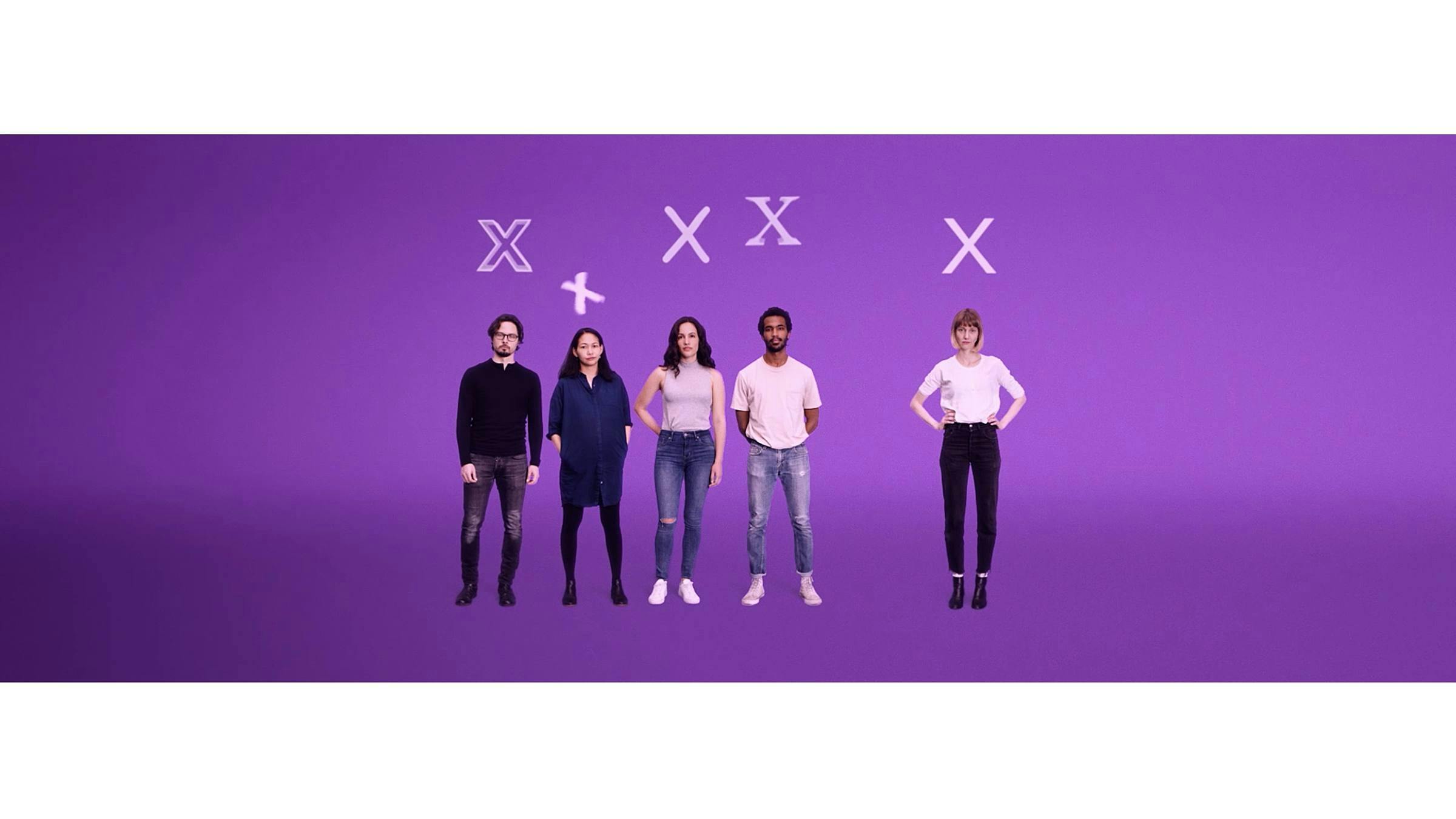 A group of people stand in front of a purple background, they each have the letter X above their heads