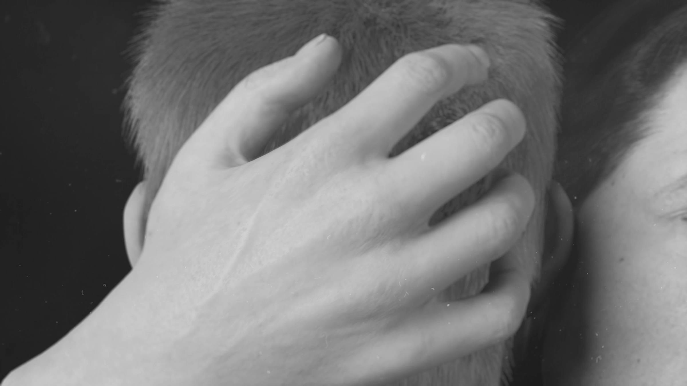 a digitally rendered hand rests on the back of a person's head