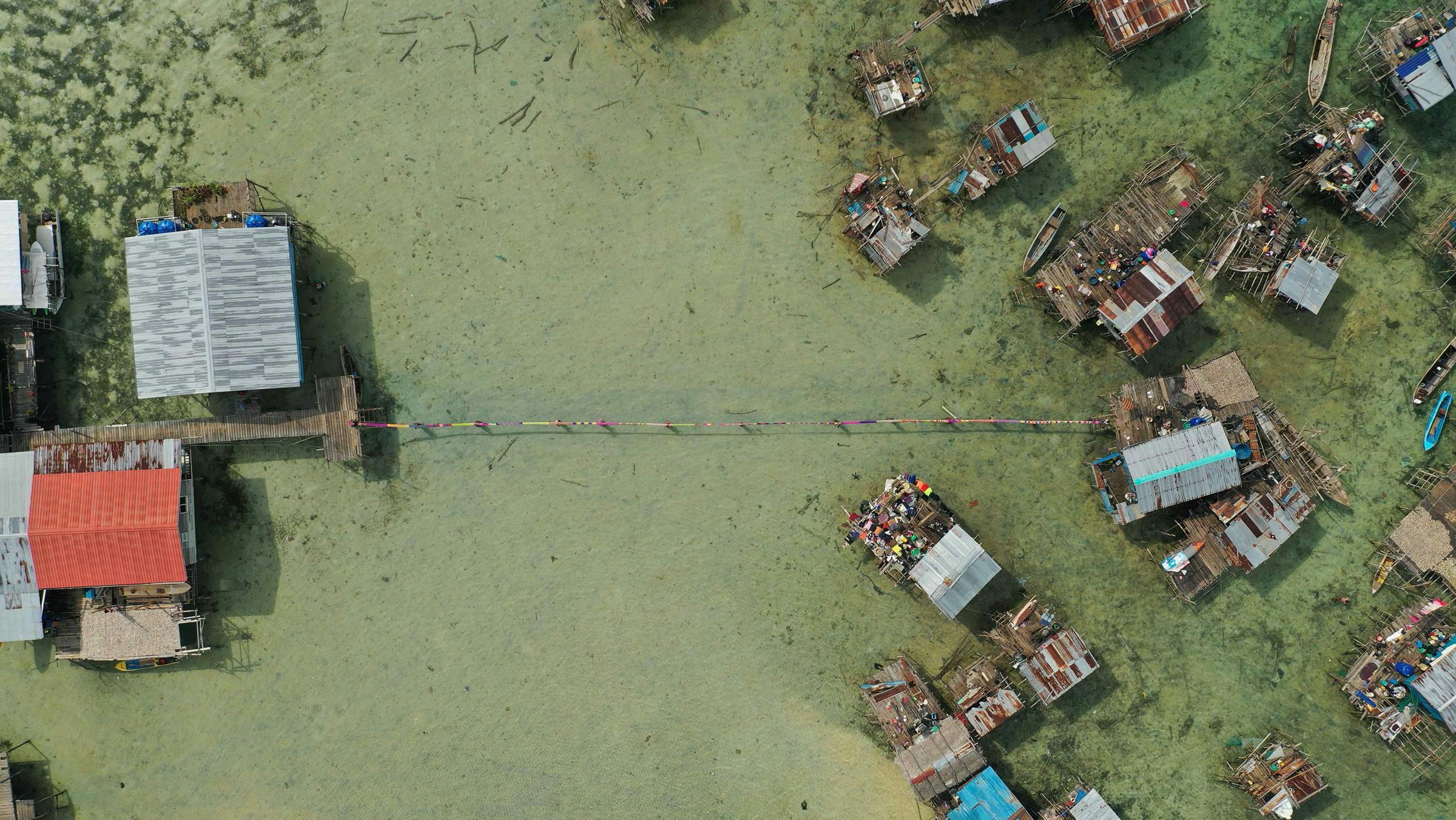 an aerial view of a flooded town in Omadal Island. The water has a green surface