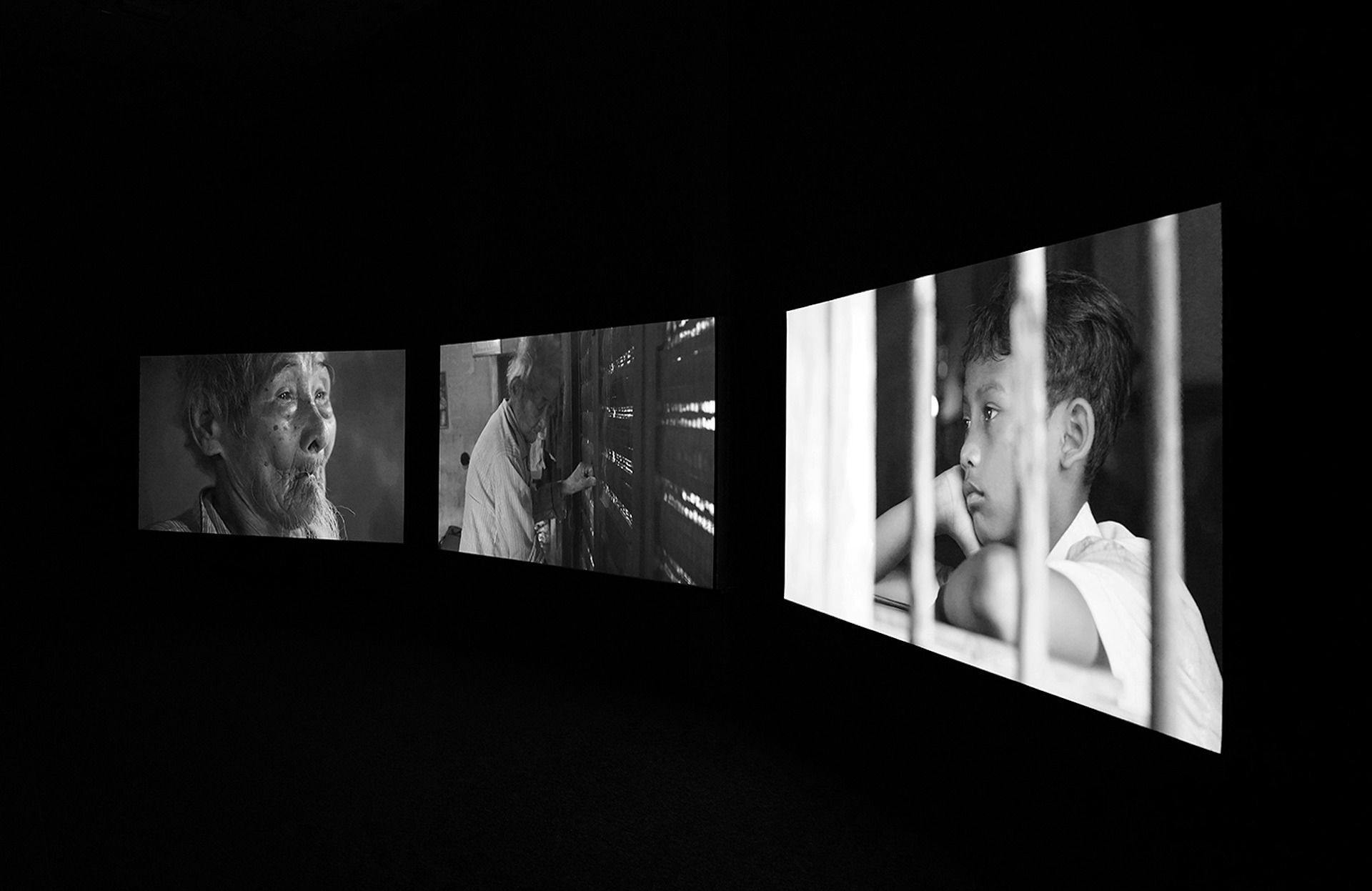 a 3 channel art work installed in a dark gallery space. 