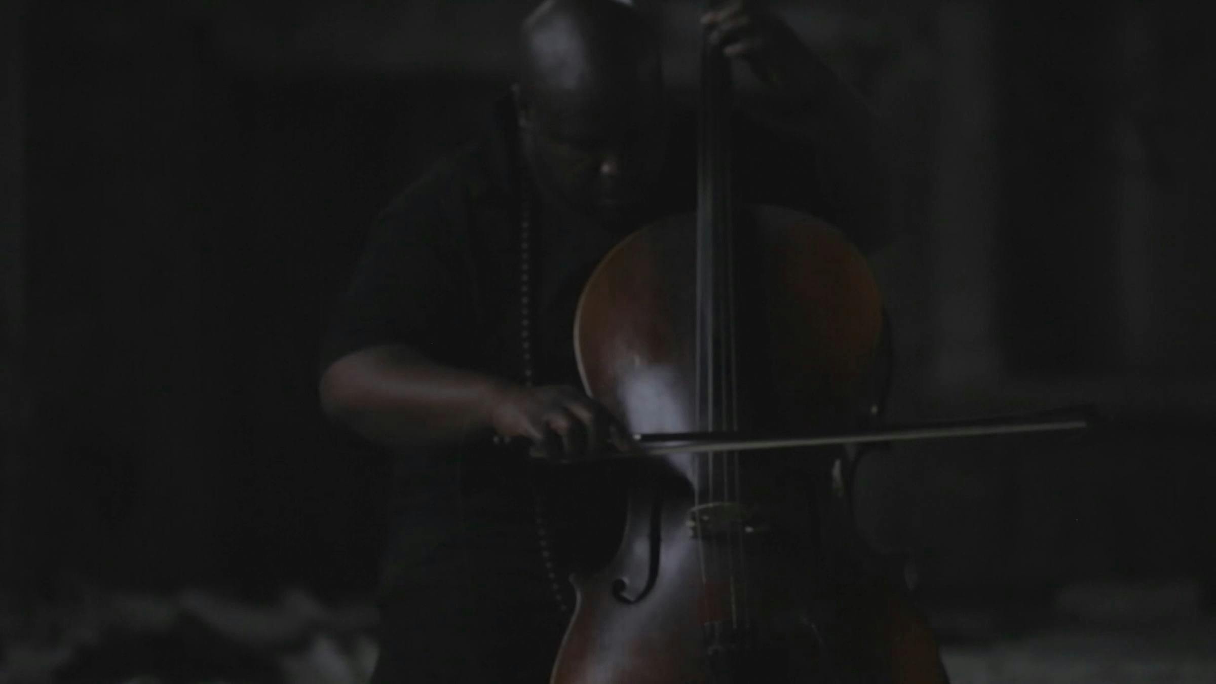 An image of a black person playing the cello